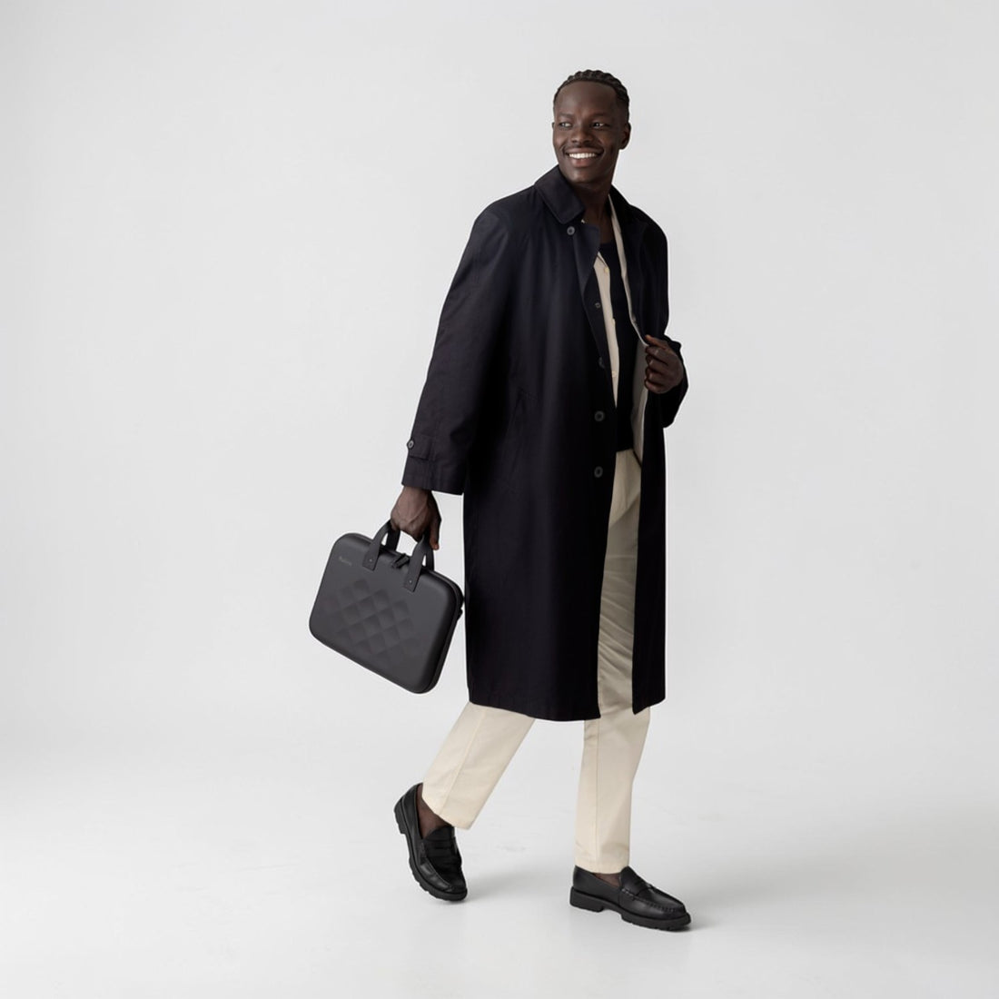 Man wearing a black coat holding a Rollink laptop case tour in his hand