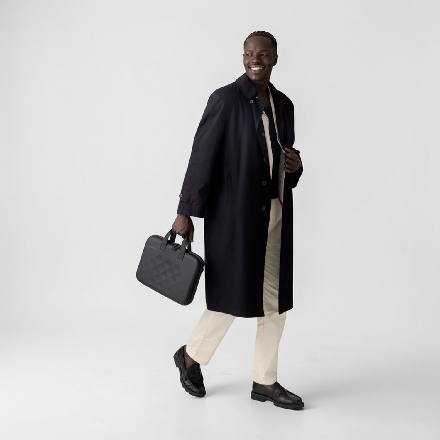 Man wearing a black coat holding a Rollink laptop case tour in his hand