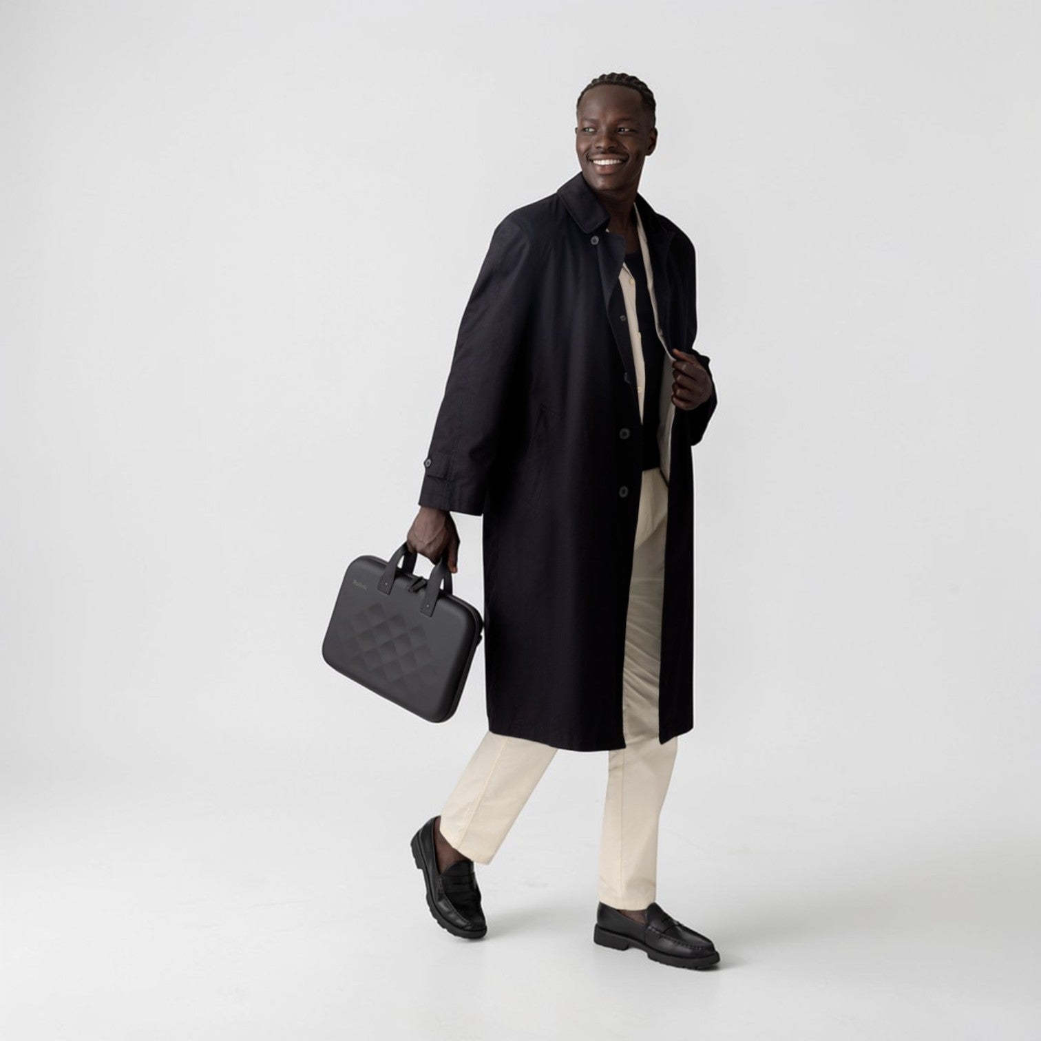 Man wearing a black coat holding a Rollink laptop case tour in his hand