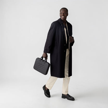 Man wearing a black coat holding a Rollink laptop case tour in his hand
